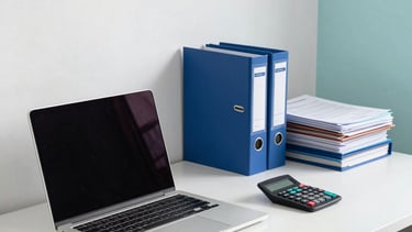 Photography of a professional South American / Brazilian accounting office interior in Santarém. A clean desk features a modern laptop, organized tax folders, and a calculator. The atmosphere is trustworthy and bright, with subtle accents of steel blue and light cyan in the decor.