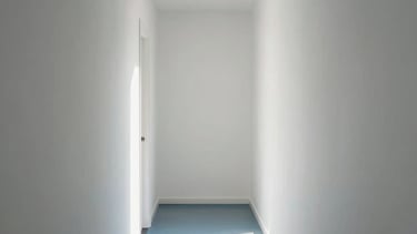 Clean photo of a white hallway with perfectly smooth drywall surfaces. Minimalist aesthetic, steel blue floor, soft morning light in a Brazilian apartment.