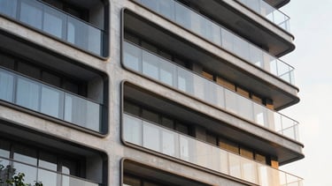 Architectural close-up of modern structural glass facade reflecting golden hour light, clean concrete lines, luxury development exterior.