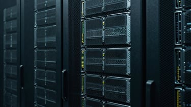 A rack of high-performance servers in a dark, cool data center. Muted teal glow. Representing the technical power and security behind our post-production process.