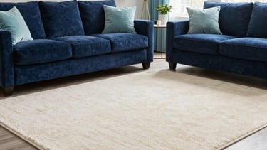 A high-end, modern North American living room showcasing a pristine, perfectly cleaned cream-colored area rug. The setting includes navy blue velvet furniture, soft cyan decorative accents, and bright natural light streaming through large windows. The overall composition is professional and clean.