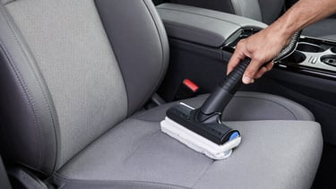 Close-up of a car seat being professionally cleaned with foam
