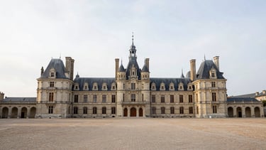The historic Château de Compiègne facade under soft overcast sky, wide-angle architectural photography, serene and empty square, 35mm