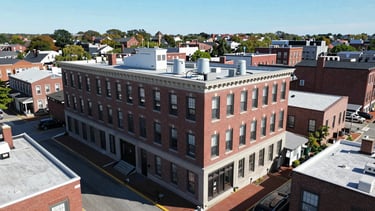 Wide aerial view of 116 Center St, Pembroke, MA 02359, showing the building and surrounding area, under bright natural daylight, crisp focus.