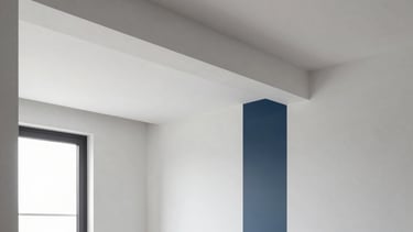 Architectural photography of a clean, modern apartment renovation in Braga, Northern Portugal. The scene highlights perfectly finished white Pladur walls and a seamless ceiling with integrated light troughs. The style is professional and minimalist, with soft natural light entering from a large window. Accents of slate blue and dark blue in the decor.