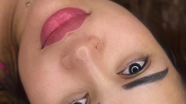 a woman with a pink top and black eyebrows