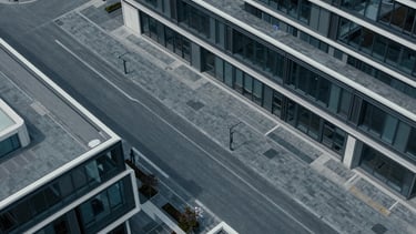 Top-down view of a modern urban planning layout with clean geometric lines, cool diffused daylight, high contrast, desaturated slate and deep blue tones.