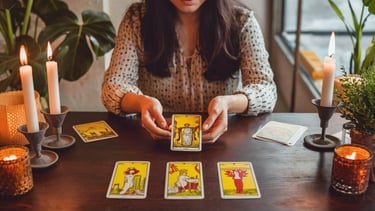 a woman holding a tarot card game with candles and candles