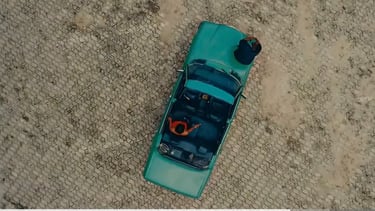 a blue green car with a red and white stripe on the top of it