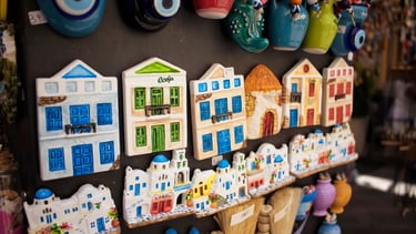 Souvenirs típicos de Corfu, com casinhas coloridas à venda nas lojas locais, refletindo o charme.