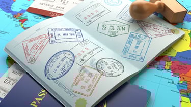 Páginas de passaporte abertas com vistos e carimbos de diferentes países.
