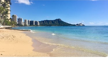 Vista da praia de Waikiki com mar calmo e a cidade de Honolulu ao fundo