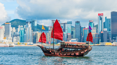 Barco de passeio navegando pela baía de Hong Kong em um dia ensolarado.