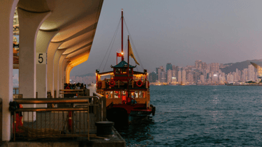 Pier de embarque do ferry em Hong Kong com passageiros prontos para passeio pela baía.