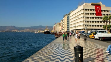 Vista do pier no porto de Izmir, com pessoas indo e vindo, capturando o movimento da cidade.