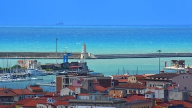 Vista do porto de Livorno com o farol e o mar azul ao fundo.