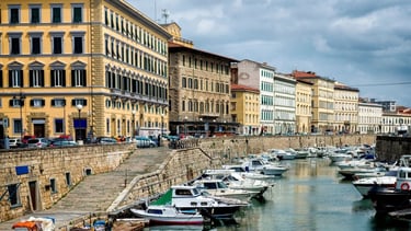 Barcos ancorados nos canais de Livorno, em cenário que lembra Veneza