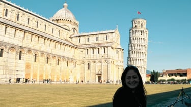 Catedral histórica com torre inclinada ao fundo em cenário ensolarado da Toscana