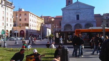 Praça central de Livorno com turistas e atividades ao ar livre.