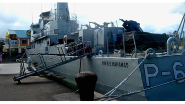 Navio militar ancorado no porto de Nassau garantindo a segurança.