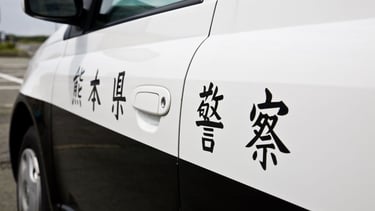 Veículo policial nas ruas de Osaka, refletindo ordem e segurança urbana
