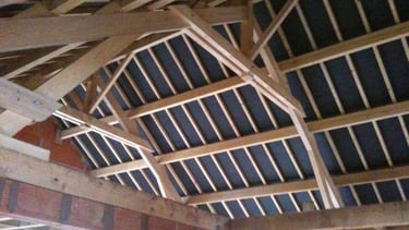 Charpente traditionnelle avec fermes pour une maison d'habitation.