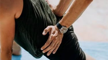 Lower back massage being done by applying pressure while client is in a stretch