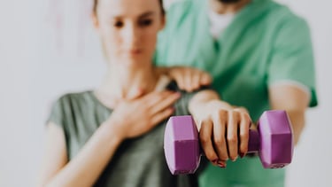 Un homme en vêtement médical assiste une femme dans un exercice de rééducation musculaire
