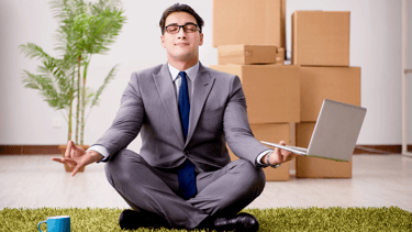 Figura di un impiegato seduto a terra  gambe incrociate in meditazione in un ufficio