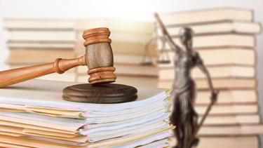 Sudski čekić na hrpi dokumenata s figurom pravde u pozadini , upravno pravo