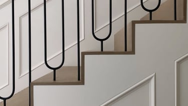 Custom staircase design with curved metal balusters and wood handrail for upscale interior