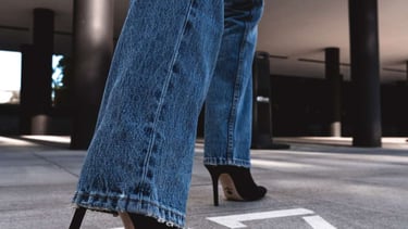 MULHER COM CALÇA JEANS E SALTO ALTO