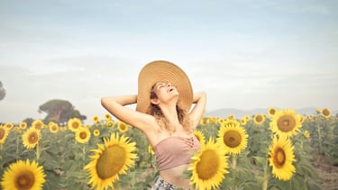Mulher feliz ao redor de vários girassóis