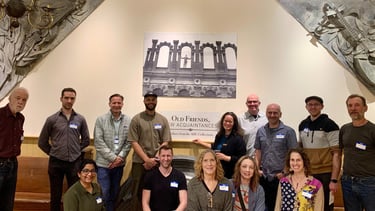 Members of PDT in front of a sign at the AHC saying Old Friends, New Acquaintances