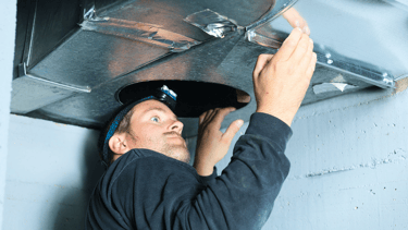 a man in a black hat and a hat on a metal pipe
