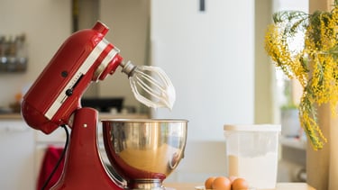 a red mixer with eggs and eggs in a kitchen