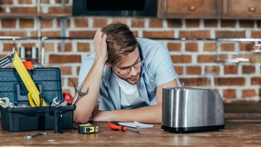 a man sitting at a table with tools and tools