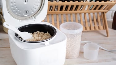 a rice cooker with rice and a bowl of rice