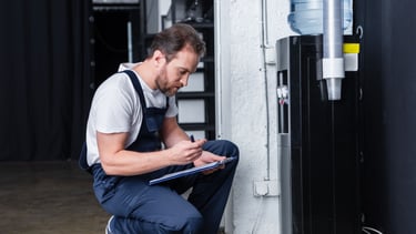 a man in overalls and overalls sitting on a stool