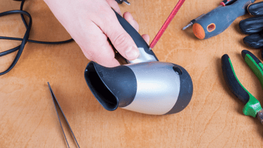 a person holding a hair dryer in their hand