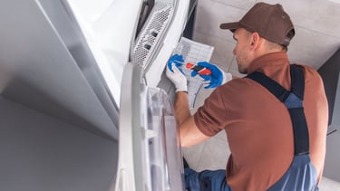 a man in a brown shirt and blue overalls and a hat