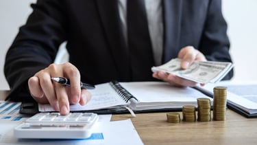 a man in a suit and tie is holding a pen and a notebook. Accounting.Bookkeeping. Taxes.Notary Public