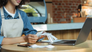 a woman in aprons and aprons is holding a credit card. Accounting- Taxes.