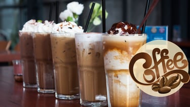 a group of three glasses of iced coffee with coffee beans and milk