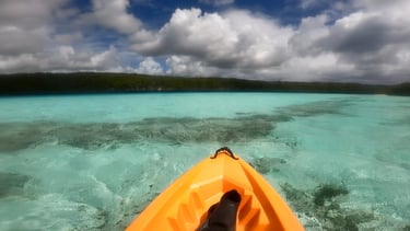 a kayak in the water with a view of a boat