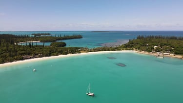 a sailboat in the ocean near a beach