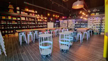 Intérieur de boutique de vin moderne et de bar à bière artisanale avec tabourets en métal blanc