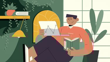 bir elinde laptop bir elinde kitapla  kanepede oturan bir adam