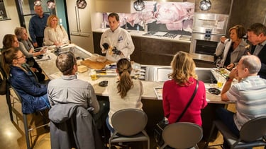 Chef Andrew gives a presentation on luxury kitchen appliances to a group of people.