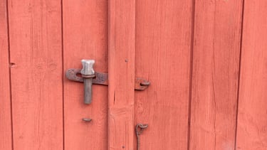 Une vielle porte de ferme en bois avec loqupeinte en peinture naturelle respectueuse du bois et avec une longue durée de vie